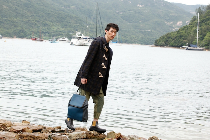 Duffle coat with shirt, trousers and Goya backpack, all by Loewe; Ankle boots by Tod’s Image
