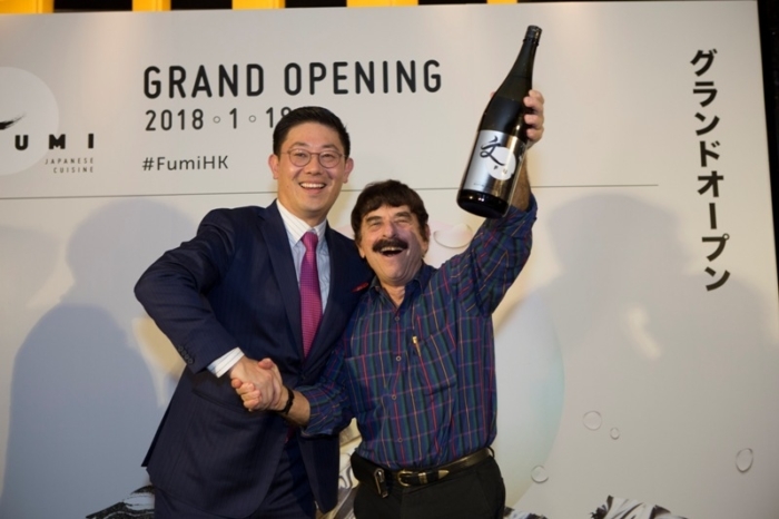 A lucky guest wins a bottle of sake at Fumi’s grand opening party. Image
