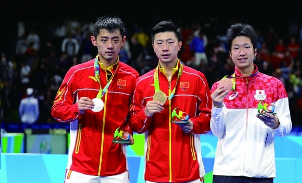 Ma Long, of China, center, holds his gold medal as he stands with silver medalist Zhang Jike, of China, left, and bronze medal winner Jun Mizutani, of Japan, right, after the men's table tennis gold medal match at the 2016 Summer Olympics in Rio de Janeiro, Brazil, Thursday, Aug. 11, 2016. (AP Photo/Petros Giannakouris)