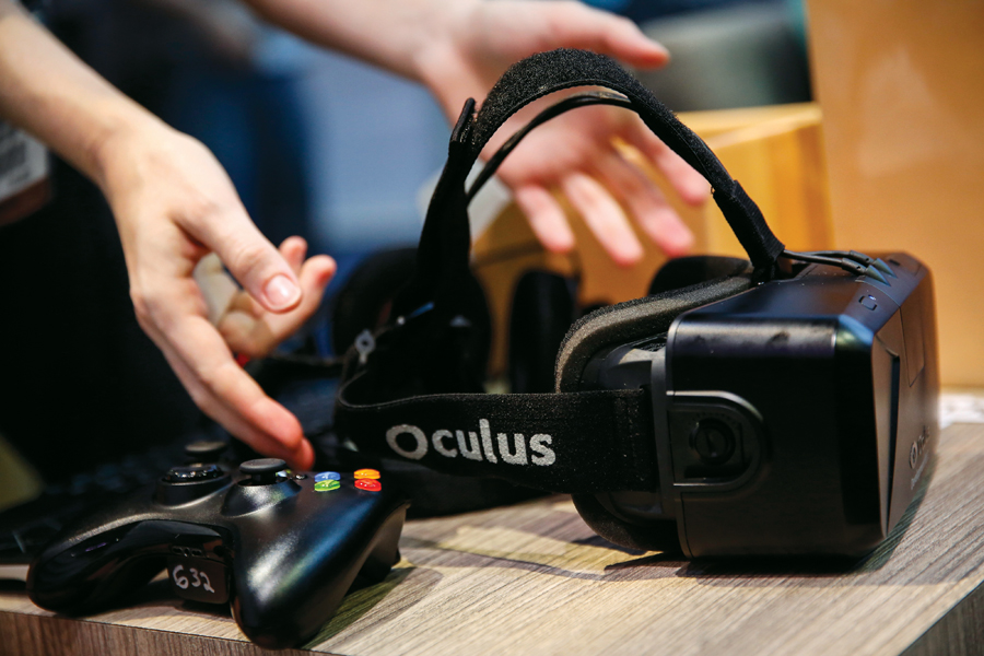 An Oculus VR Inc. Rift Development Kit 2 headset is displayed with a controller during the E3 Electronic Entertainment Expo in Los Angeles, California, U.S., on Wednesday, June 11, 2014. E3, a trade show for computer and video games, draws professionals to experience the future of interactive entertainment as well as to see new technologies and never-before-seen products. Photographer: Patrick T. Fallon/Bloomberg via Getty Images